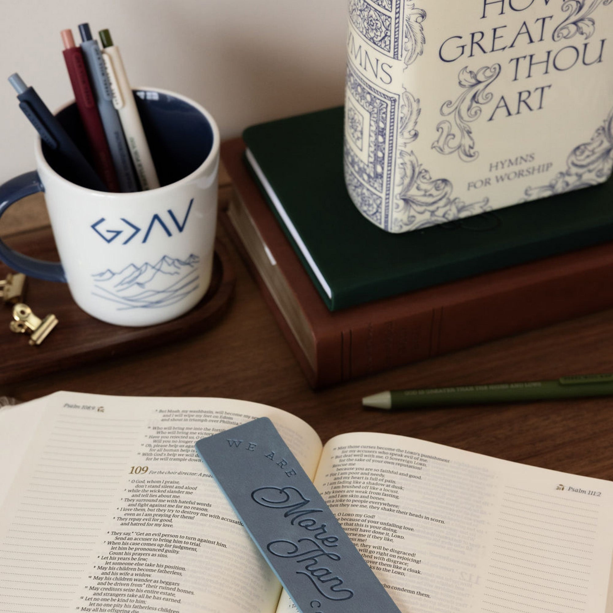 White mug with blue interior and handle, featuring 'G>AV' text and mountain design on a white background on a desk