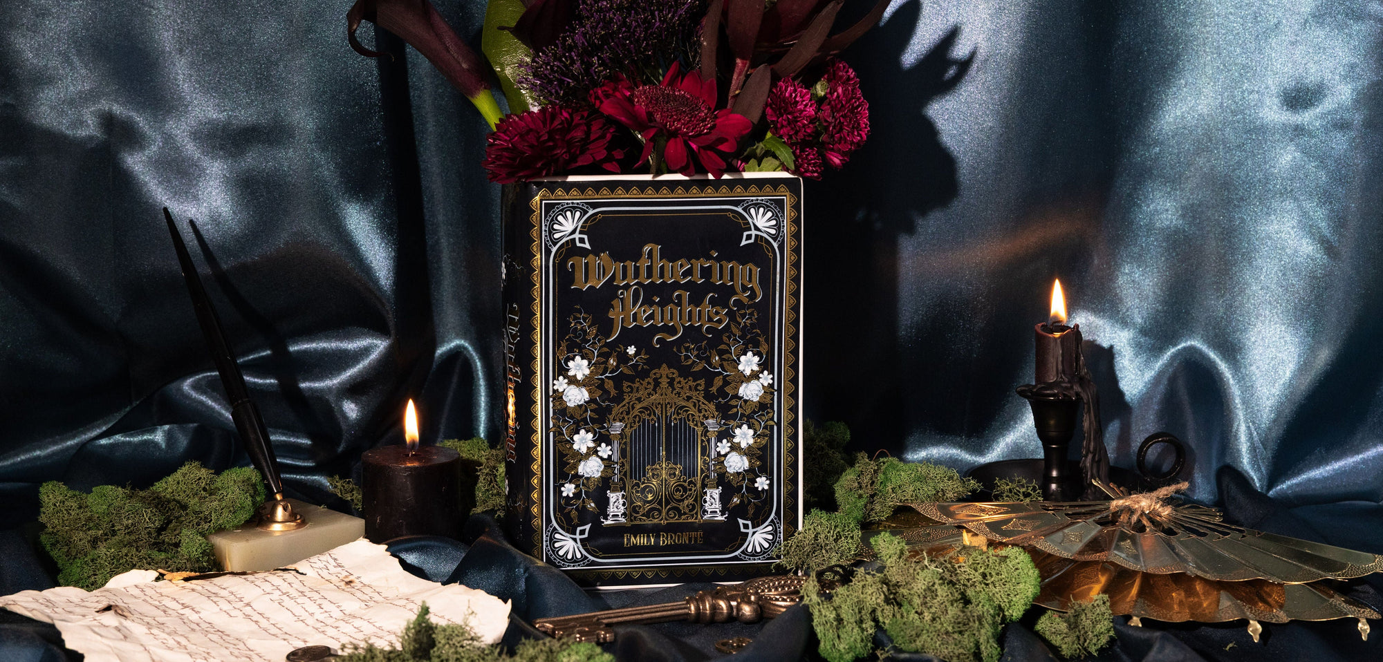 Book titled 'Wuthering Heights' with flowers and candles on a dark background