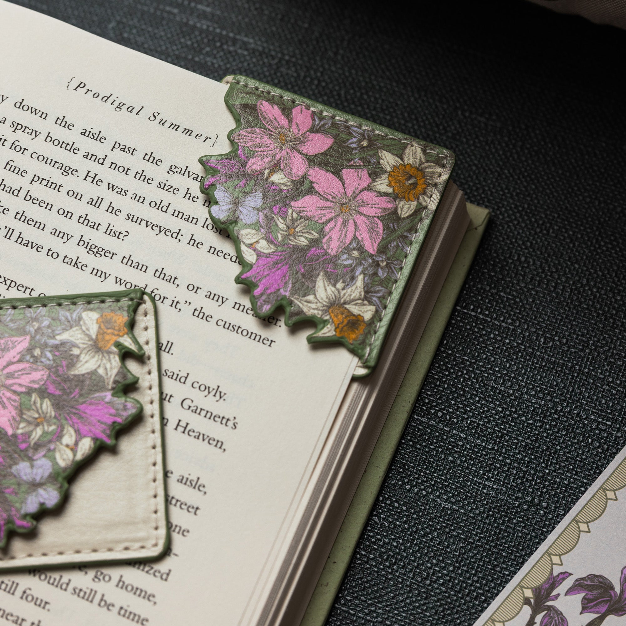 Floral bookmark on an open book with a dark textured background