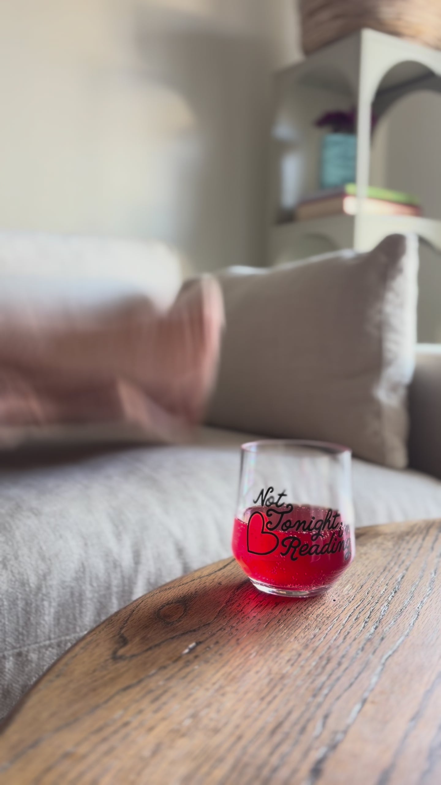 model having a red drink out of 'not tonight, reading' wine glass